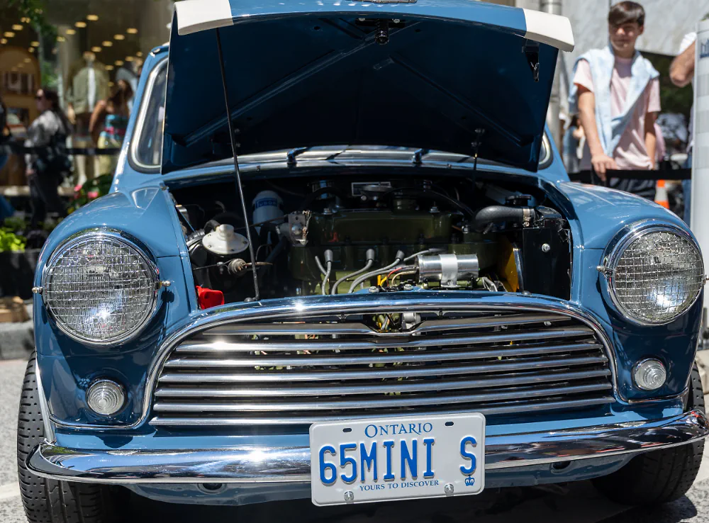 Blue classic Mini Cooper with the hood open, engine bay visible.